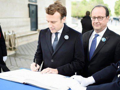 Les présidents sortant et élu François Hollande (D) et Emmanuel Macron signent le livre d'or le 8 mai 2017 sous l'Arc de Triomphe place de l'Étoile - STEPHANE DE SAKUTIN [POOL/AFP]