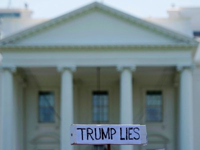 Un manifestant tient une pancarte "Trump ment" lors d'une manifestation devant la Maison-blanche, le 10 mai 2017 à Washington - JIM WATSON [AFP]