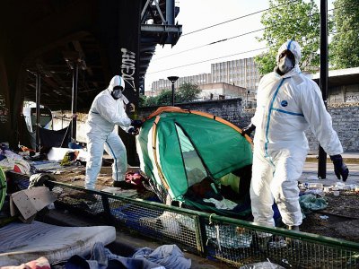 Des employés nettoient le camp illicite évacué près de La Chapelle à Paris le 9 mai 2017 - PHILIPPE LOPEZ [AFP/Archives]