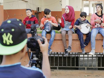 "Quand je joue, je me sens comme une star", se réjouit Hanadi, fillette coiffée d'un voile couleur rouge brun qui, il y a quatre ans, avait fui sa maison près de Damas. - JOSEPH EID [AFP]