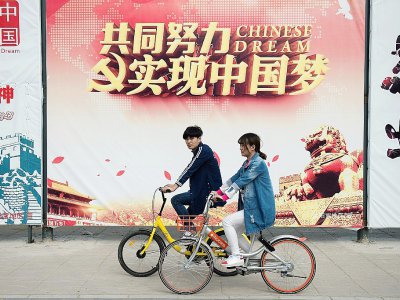 Des cyclistes sur des vélos partagés dans une rue de Pékin le 5 avril 2017 - Nicolas ASFOURI [AFP]