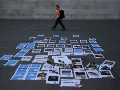Des photos des morts et des blessés ont été disposés sur le sol à Trafalgar Square à Londres, le 23 mai 2017 - Daniel LEAL-OLIVAS [AFP]