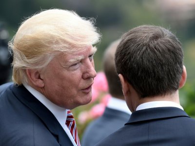Le président américain Donald Trump glissant un mot à l'oreille d'Emmanuel Macron au G7 à Taormina en Italie, le 26 mai 2017 - STEPHANE DE SAKUTIN [POOL/AFP]