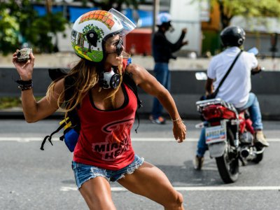 Une opposante s'apprête à lancer une pierre contre les forces de police, le 1er mai 2017 à Caracas, au Venezuela - FEDERICO PARRA [AFP/Archives]
