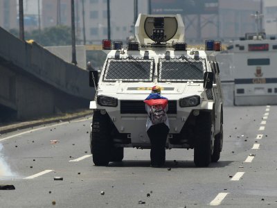 Une opposante bloque un véhicule blindé de la police antiémeute, le 19 avril 2017 à Caracas, au Venezuela - Juan BARRETO [AFP/Archives]