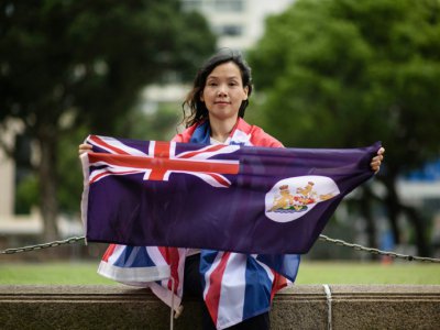 L'artiste Alice Lai, à la tête d'un petit groupe de protestataires, tient l'ancien drapeau de Hong Kong orné de l'Union Jack, d'un dragon et d'un lion, le 18 mai 2017 - Anthony WALLACE [AFP]