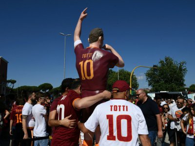 Des supporters de l'AS Rome posent à côté d'une statue de Francesco Totti à quelques heures de son dernier match sous le maillot de la Roma, le 28 mai 2017 au Stade Olympique - Vincenzo PINTO [AFP]