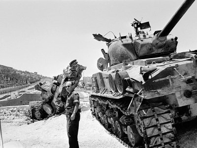 Un soldat israélien inspecte un tank détruit sur une route entre Bethléem et Jérusalem, en juin 1967 - Pierre GUILLAUD [AFP/Archives]