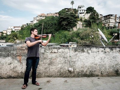 Michel Dionisio, violoniste de 19 ans, répète sur le toit de sa maison dans le complexe de Maré, un ensemble de favelas qui regroupe 140.000 habitants à Rio. - Yasuyoshi CHIBA [AFP]