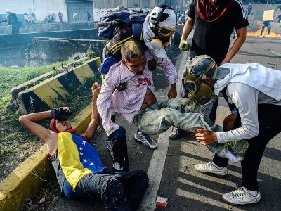 Des manifestants secourent des blessés après des heurts avec les forces de l'ordre vénézuéliennes, le 31 mai 2017 à Caracas - FEDERICO PARRA [AFP]