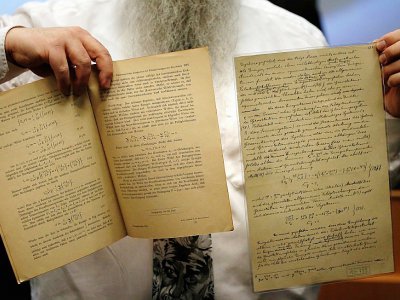 Le docteur Roni Grosz montre des documents originaux écrits par Albert Einstein, et prédisant la découverte future d'ondes gravitationnelles, à Jérusalem, le 11 février 2016 - THOMAS COEX [AFP]