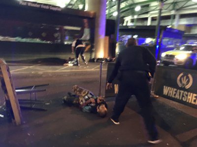 Un policier armé à côté de deux suspects à terre à Borough Market, dans le centre de Londres, le 3 juin 2017 - Gabriele SCIOTTO [AFP]