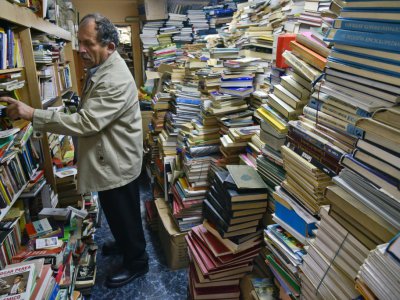 José Alberto Gutierrez au milieu des livres entassés dans sa bibliothèque à son domicile de Bogota le 18 mai 2017 - GUILLERMO LEGARIA [AFP]