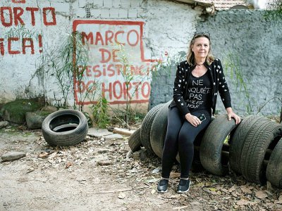 Nelia Vasconcelos, retraitée et membre de la communauté d'Horto, montre du doigt les troncs et pneus empilés en divers endroits stratégiques, des barricades de fortune censées repousser les éventuels assauts de la police. - YASUYOSHI CHIBA [AFP]