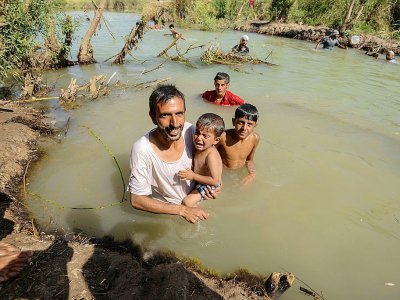 Des Irakiens du camp d'Al-Khazir nagent dans la rivière entre Arbil et Mossoul, le 11 juin 2017 - MOHAMED EL-SHAHED [AFP]