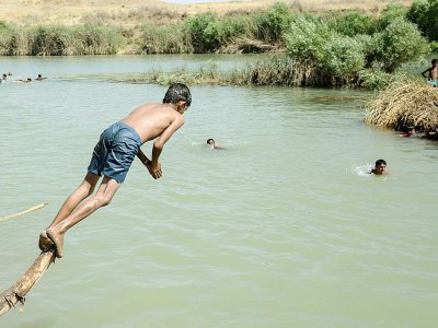 Un jeune Irakien du camp d'Al-Khazir nagent dans la rivière entre Arbil et Mossoul, le 11 juin 2017 - MOHAMED EL-SHAHED [AFP]