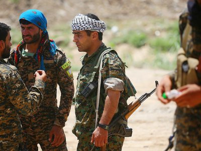 Des membres de la force kurdo-arabe soutenue par les Etats-Unis, le 11 juin 2017 dans un quartier de Raqa, fief du groupe Etat islamique (EI) en Syrie - DELIL SOULEIMAN [AFP]
