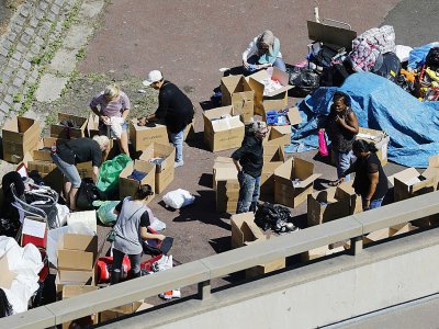 Des Londoniens déposent des cartons de vêtements, de l'eau, de la nourriture sous le pont de la voie rapide A40, qui longe la tour Grenfell, le 15 juin 2017 - Tolga AKMEN [AFP]