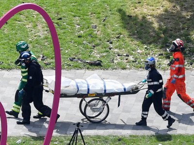 Des policers et des secouristes évacuent le corps d'une victime de l'incendie de la tour Grenfell à Londres, le 16 juin 2017 - Chris J Ratcliffe [AFP]