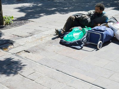 Un homme sans abri allongé sur le bitume, le 19 juillet 2016 à Paris - MATTHIEU ALEXANDRE [AFP]