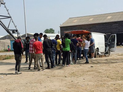 Des migrants font la queue pour recevoir des vivres distribués par une association à Calais le 21 juin 2017 - DENIS CHARLET [AFP]