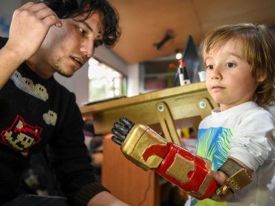 Le petit Colombien Daniel Garavito essaie une prothèse de la main aux couleurs d'Iron Man, le 12 juin 2017 à Bogota - RAUL ARBOLEDA [AFP]