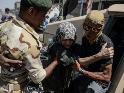 Une femme qui a fui les combats dans la Vieille ville de Mossoul, est prise en charge par les forces armées irakiennes, le 23 juin 2017 - MOHAMED EL-SHAHED [AFP]