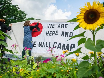 Des activistes installent une bannière sur une tente dans un parc de Hambourg, le 26 juin 2017, avant le sommet du G20 - Christina Sabrowsky [dpa/AFP]