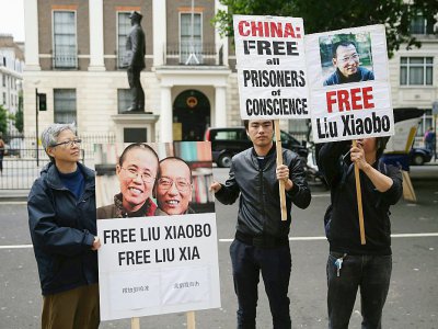Photos du dissident Liu Xiaobo sur des pancartes dans une manifestation à Londres le 1er juillet 2017 - Daniel LEAL-OLIVAS [AFP/Archives]