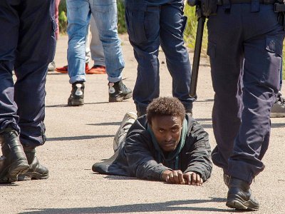 Un migrant est au sol face à des policiers le 1er juin 2017 à Calais - PHILIPPE HUGUEN [AFP]