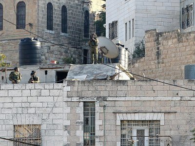 Image d'archives prise le 21 octobre 2015 montrant des membres des forces de sécurité israéliennes sur le toit d'une maison à Hébron pendant des affrontements avec des manifestants palestiniens - HAZEM BADER [AFP/Archives]