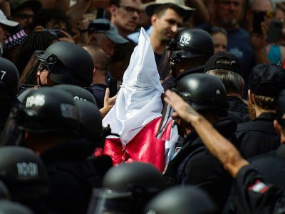 Un membre du Klux Klux Klan escorté par les forces de l'ordre, le 8 juillet 2017 à Charlottesville en Virginie - ANDREW CABALLERO-REYNOLDS [AFP]
