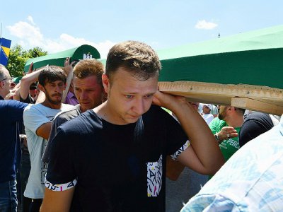 Des musulmans bosniaques, survivants du massacre de Srebrenica, en compagnie de visiteurs, transportent des restes de victimes du massacre, 11 juillet 2017 au mémorial de Potocari, près de Srebrenica, avant leurs funérailles - ELVIS BARUKCIC [AFP]