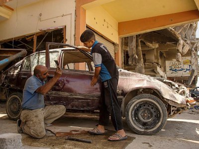 Un Irakien de Mossoul ouest répare une voiture, le 12 juillet 2017 - FADEL SENNA [AFP]