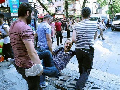 Des policiers en civil entraînent un manifestant lors d'un rassemblement le 14 juillet 2017 à Ankara, en soutien à deux professeurs victimes des purges opérées par le pouvoir - ADEM ALTAN [AFP]