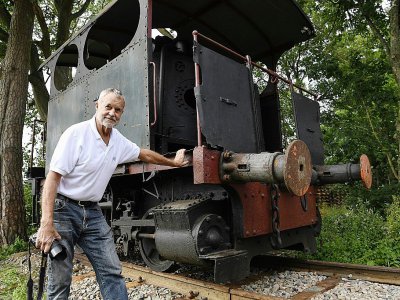 L'Américain Grégory Marshall devant une  locomotive à vapeur, dans l'ancienne gare de Dracy-Saint-Loup, le 11 juillet 2017 en Saône-et-Loire - PHILIPPE DESMAZES [AFP]