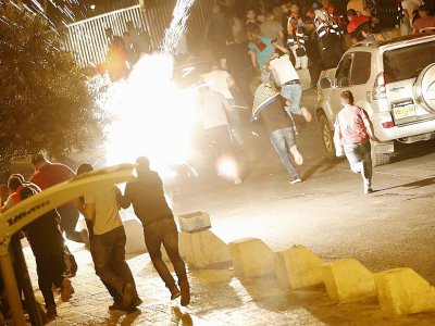 Des Palestiniens se mettent à l'abri tandis que l'armée israélienne tire pour disperser la foule devant l'esplanade des Mosquées, le 23 juillet 2017. - Ahmad GHARABLI [AFP]