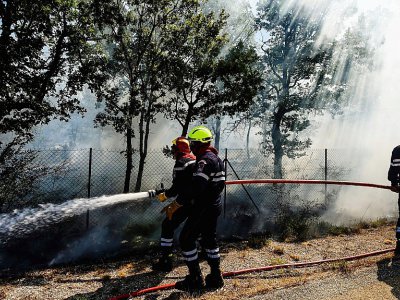 Des pompiers tentent d'éteindre un incendie à Artigues, dans le Var, le 25 juillet 2017 - Anne-Christine POUJOULAT [AFP]