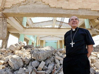 Le cardinal Philippe Barbarin marche parmi les ruines de l'église assyrienne des Martyrs ne reste plus que des murs défoncés, à Mossoul le 25 juillet 2017 - SAFIN HAMED [AFP]