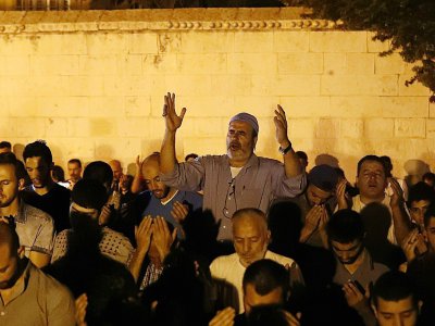 Des Palestiniens musulmans prient devant le Vieille ville de Jérusalem, le 25 juillet 2017 - Ahmad GHARABLI [AFP]