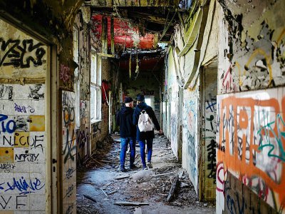 De jeunes explorateurs urbains traversent un bâtiment abandonné à Berlin, le 12 mai 2017 - John MACDOUGALL [AFP]