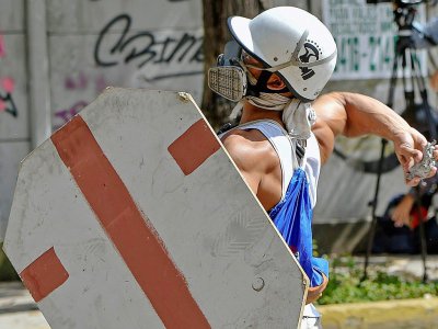 Un manifestant lance un projectile contre les forces de police, le 28 juillet 2017 à Caracas - JUAN BARRETO [AFP]