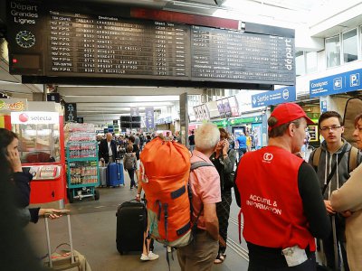 Des personnes parlent à un employé de la SNCF à Paris le 30 juillet 2017 - JACQUES DEMARTHON [AFP]