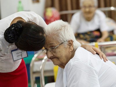 Une infirmière s'occupe d'une résidente dans la "Maison du crépuscule", centre qui receuille les personnes âgées, dans la banlieue de Rangoun, le 4 juillet 2017 - Ye Aung THU [AFP]