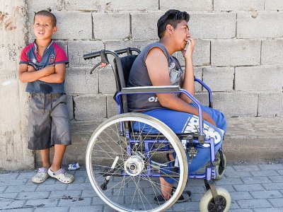 Un adolescent dans sa chaise roulante le quartier rom à Mitrovica, au Kosovo, le 7 juillet 2017 - Armend NIMANI [AFP]