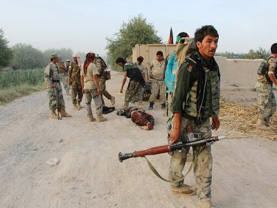 Des policiers auxiliaires autour du corps d'un homme suspecté d'être un taliban, tué lors d'une opération à Nawa dans la province du Helmand, le 17 juillet 2017 - NOOR MOHAMMAD [AFP]