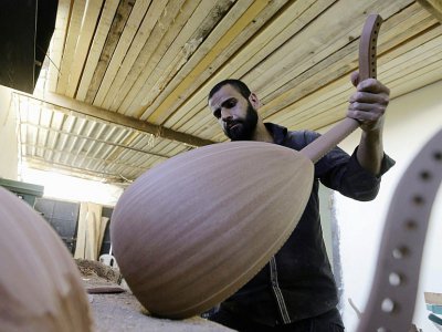 Un employé syrien dans un atelier de fabrication de luths à Damas le 17 juillet 2017 - LOUAI BESHARA [AFP]