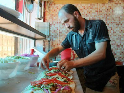 Un syrien prépare un plat dans le restaurant "Les mets damascènes Ibad al-Rahmane", dans la ville rebelle d'Idleb, en Syrie, le 19 juillet 2017 - Omar haj kadour [AFP]