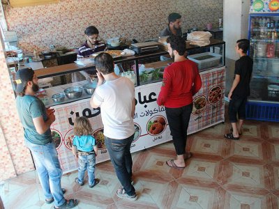 Des clients font la queue au restaurant "Les mets damascènes Ibad al-Rahmane", dans la ville rebelle d'Idleb, en Syrie, le 19 juillet 2017 - Omar haj kadour [AFP]