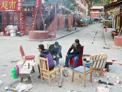 Des habitants qui ont dormi dehors par crainte de répliques tentent se se réchauffer autour d'un feu à Zhangzha dans la province du Sichuan (sud-ouest de la Chine) le 10 août 2017 au surlendemain d'un puissant séisme qui a fait au moins 20 morts - Nicolas ASFOURI [AFP]